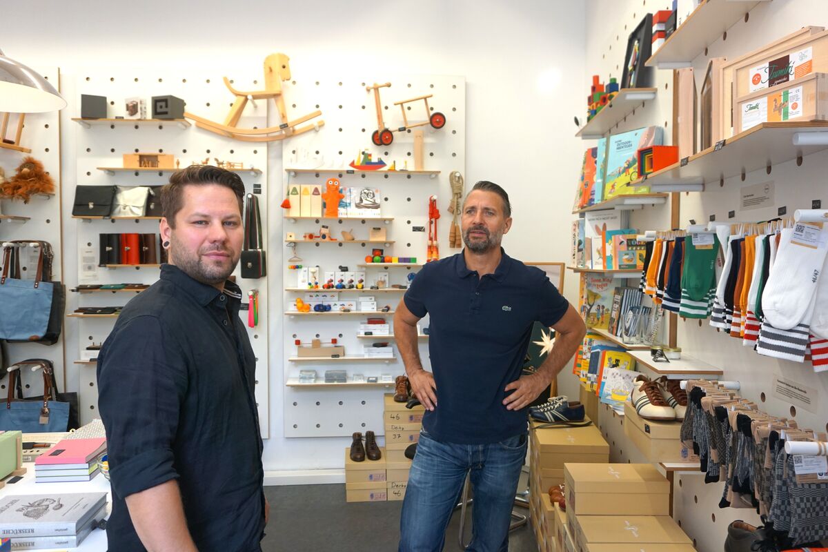 Marcel und Christian Allihn im FORMOST Store, im Hintergrund Regale mit Spielzeug, Taschen, Büchern und Schuhkartons