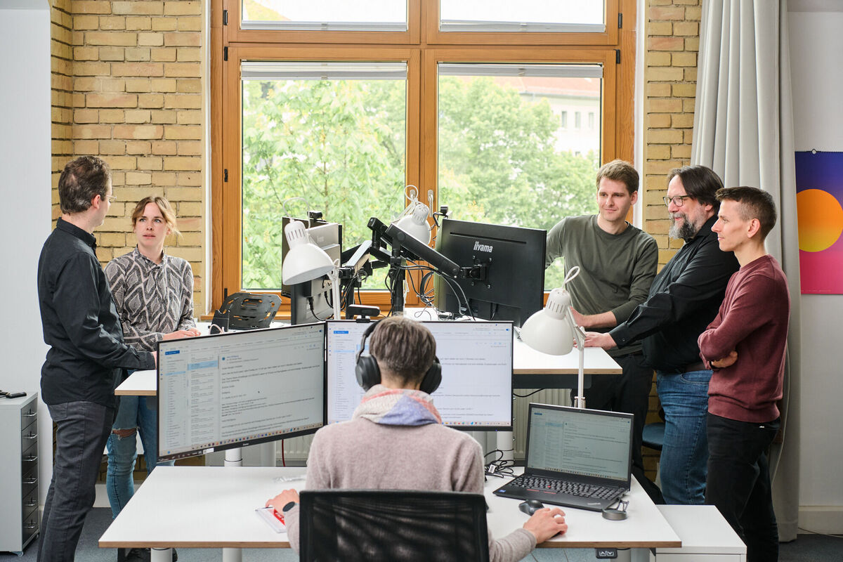 Entwicklungsteam arbeitet in Meetings und an Rechnern an maßgeschneiderten CMS-Lösungen für effizientes Content Publishing