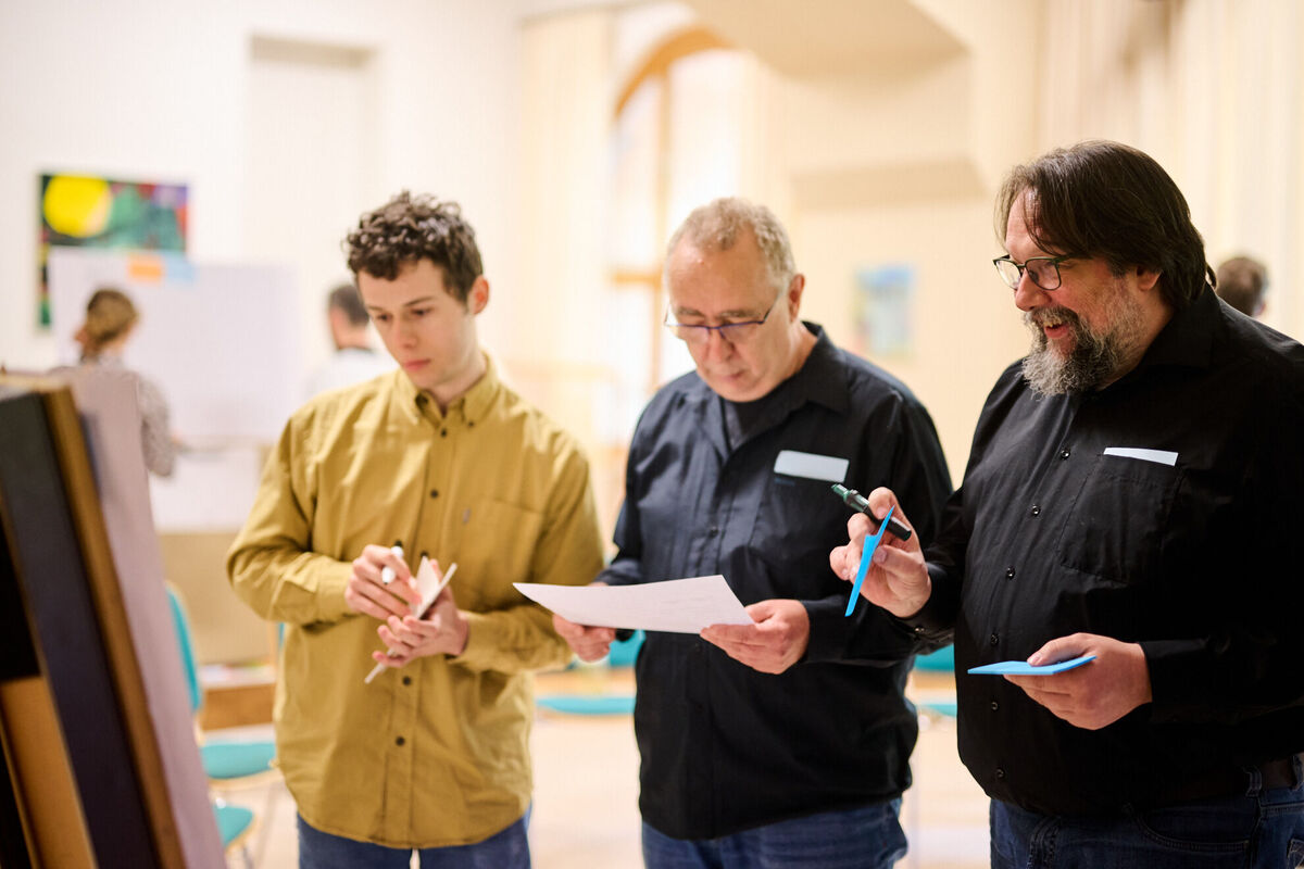 Teilnehmende in einem Workshop prüfen Unterlagen und Notizen im Rahmen der Entwicklung von Preiskonfiguratoren und Preislogiken.