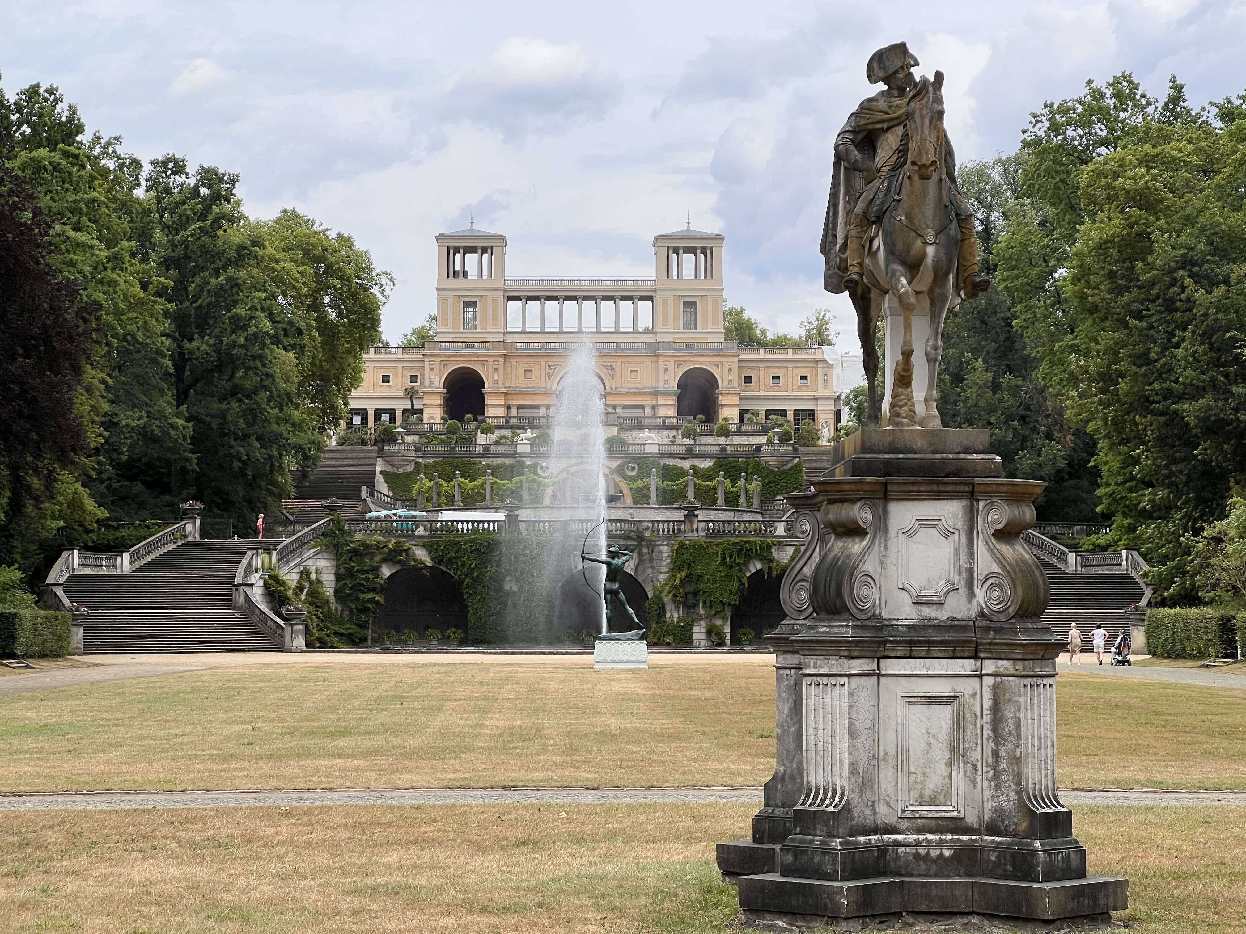 Reiterstatue Friedrichs des Großen, um 1865 von Schülern Christian Daniel Rauchs geschaffen, steht hoch zu Ross vor der Orangerie im Park Sanssouci. 