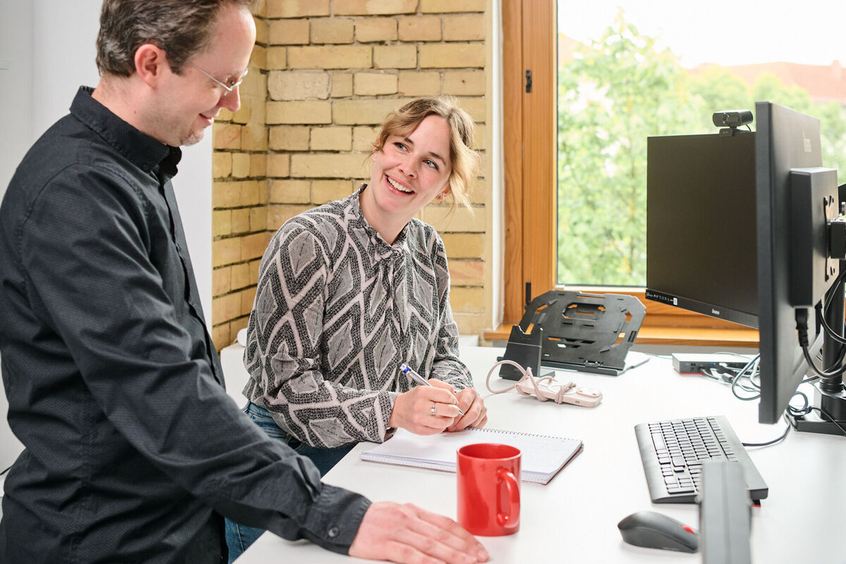 Weitere Vorteile der Digital Experience Platform entdecken Zwei Teammitglieder tauschen sich über innovative Softwareentwicklung für digitale Kundenerlebnisse aus